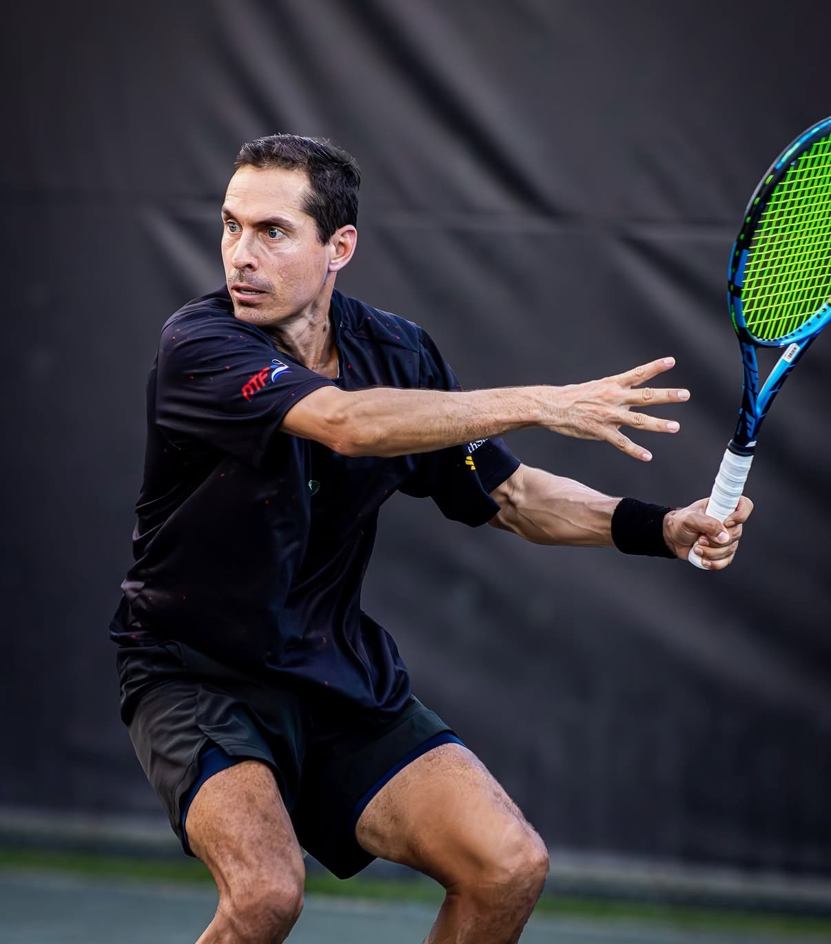 Aaron Krisan preparing a two-handed backhand during competitive match play